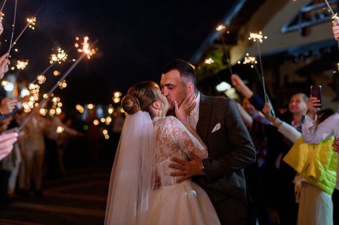 Side View Beautiful Bride Bridegroom Which Hugging Kissing Each Other While Guests Holding Cold Sparkles Which Burning Creating Glowing Arch Night Ceremony Outdoor